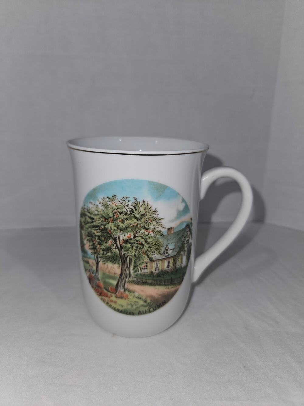 10 oz white porcelain Currier and Ives Autumn scene mug.